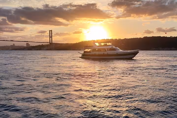 Luxury yacht cruising the Bosphorus at sunset in Istanbul with 15 July Martyrs Bridge in view