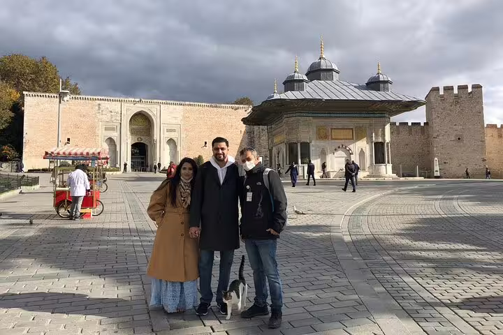 Tourists exploring the historic Topkapi Palace courtyard on a guided private tour in Istanbul.