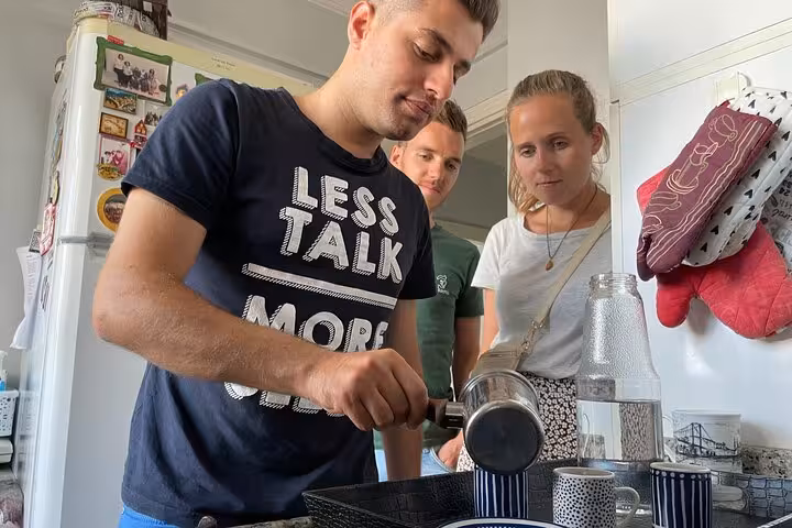 Host pours freshly brewed Turkish coffee in an Istanbul home kitchen as guests watch a hands-on local experience