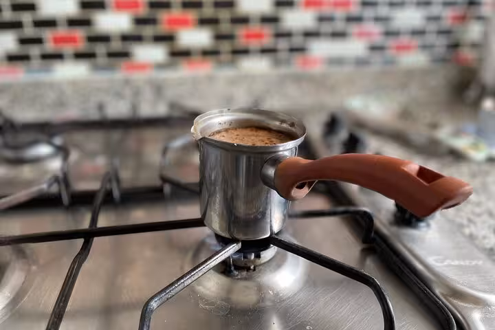 Cezve Turkish coffee simmering on a gas stove, traditional Istanbul at-home brewing for a local tasting tour