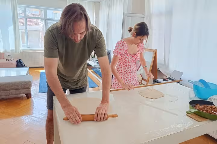 Travelers roll dough for Turkish vegan pastries at an Istanbul vegetarian home cooking class with locals