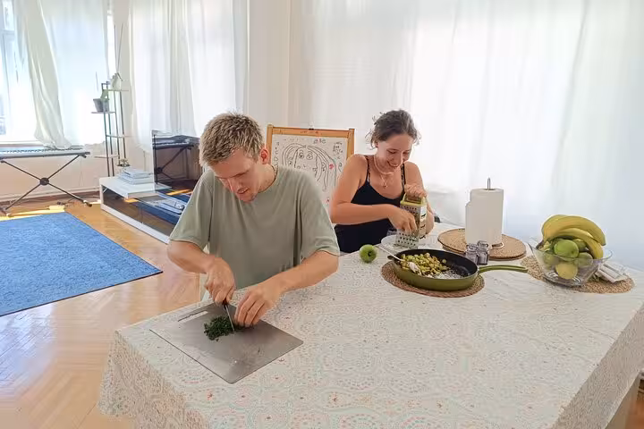 Travelers prepping herbs and veggies in an Istanbul vegan vegetarian cooking class at a local home kitchen