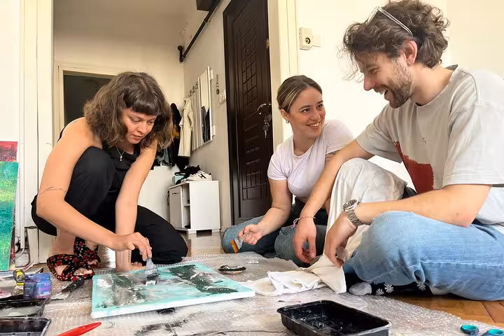 Guests painting on canvas at a local Istanbul home, enjoying an art escape wine and paint experience