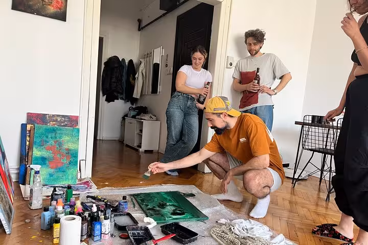 Small group Istanbul art escape wine and paint session in a local home with guests mixing paints and socializing