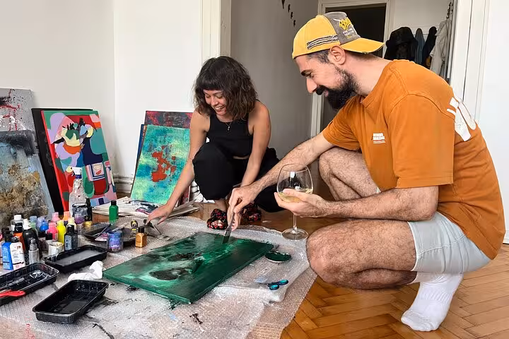 Guests painting abstract art and sipping wine at a local home in Istanbul, creative wine and paint experience