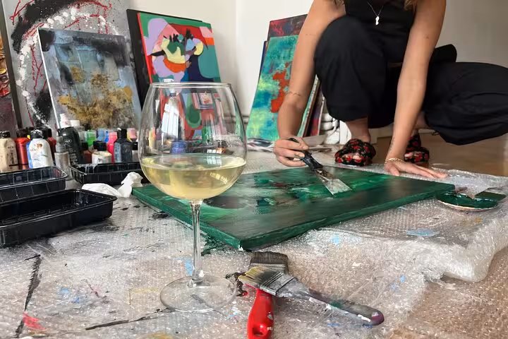 White wine glass beside acrylic paints and canvas during Istanbul wine and paint at a local’s home