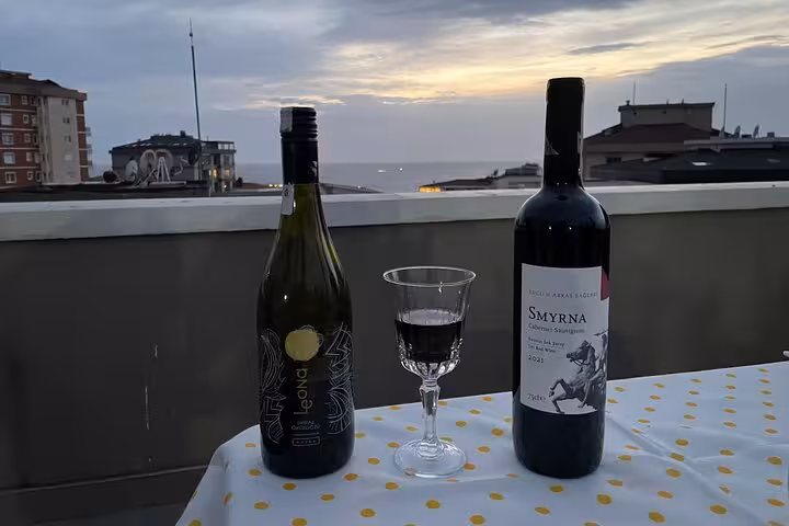 Turkish wine bottles and glass on Istanbul rooftop at sunset, at-home wine tasting with local family