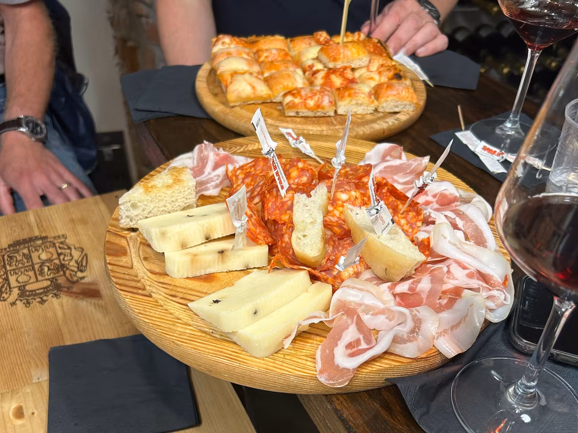 Italian charcuterie with cheese and bread, paired with red wine at a Lake Como tasting event.