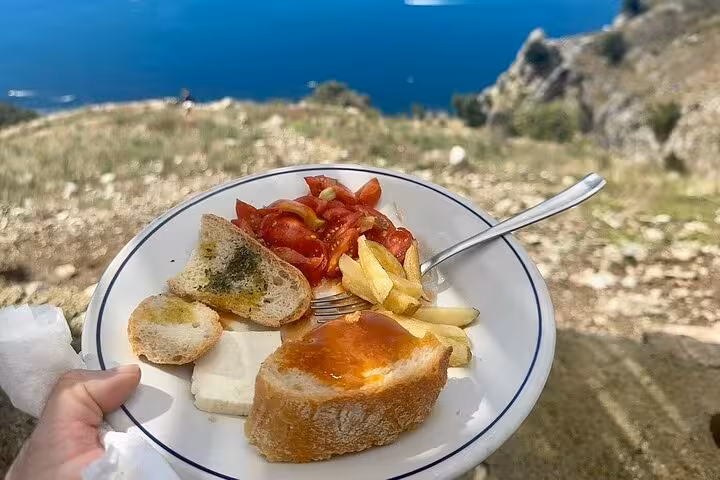 Plate of Italian snacks with Amalfi Coast view, perfect for a Path of the Gods hiking break.