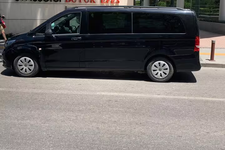 Black minivan for Izmir Airport transfer parked curbside, reliable private shuttle and hotel pickup