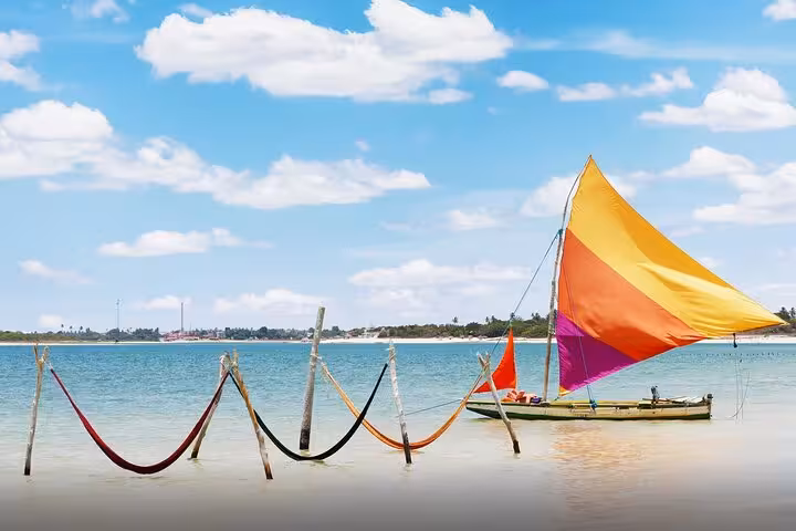 Colorful sailboat and seaside hammocks at Lagoa do Paraíso, highlight of a Jericoacoara 1-day tour