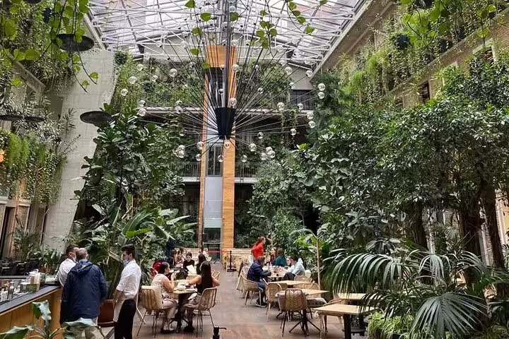 Indoor garden cafe in Budapest Jewish Quarter with glass roof, featured on a private walking tour stop