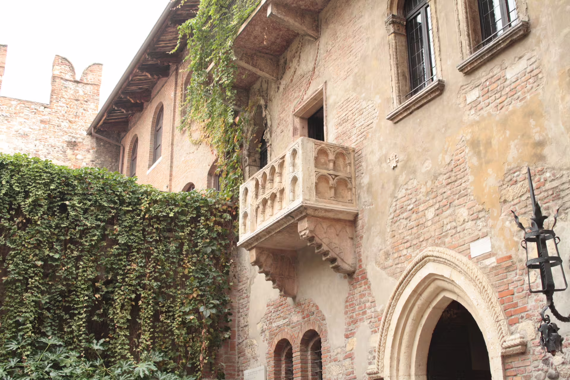 Juliet’s House in Verona with the famous stone balcony and ivy-covered courtyard on a romantic Lake Garda getaway