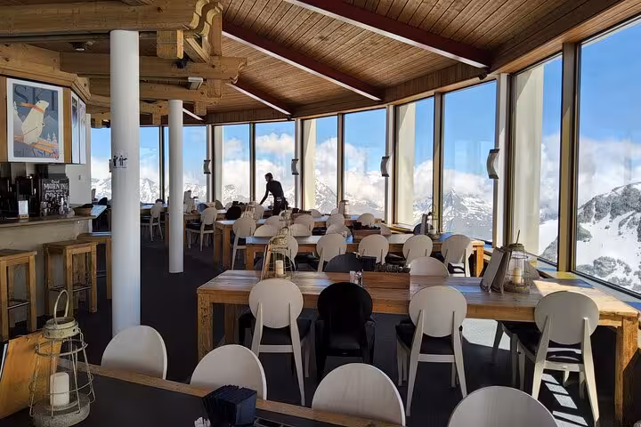 Panoramic alpine restaurant with floor-to-ceiling windows, Jungfrau Region views on Swiss Alps tour