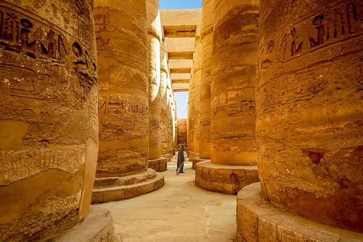 Walking corridor between massive hieroglyphic columns at Karnak Temple, Luxor day trip by bus from Hurghada