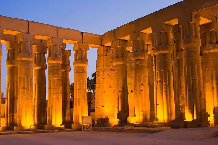 Illuminated Karnak Temple columns at dusk during Luxor Light and Sound Show with private transfer