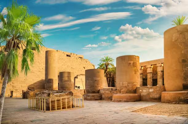 Karnak Temple courtyard in Luxor with towering columns and palm trees on a 5-day Cairo Luxor Abu Simbel tour