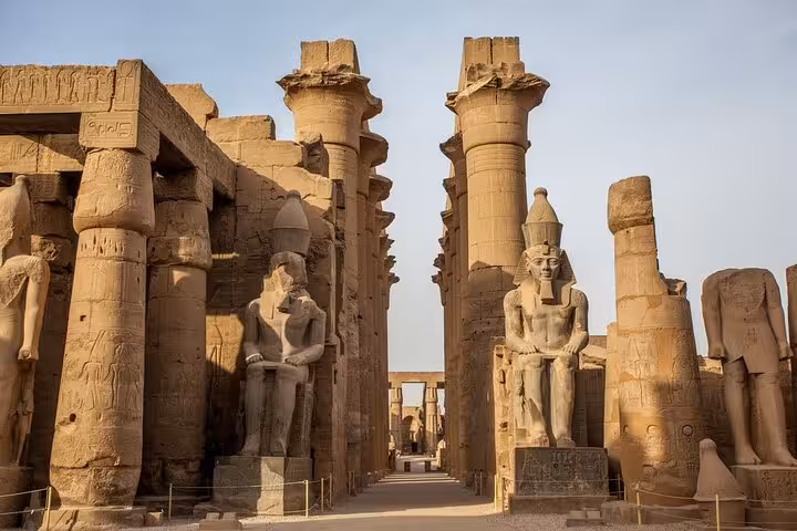 Karnak Temple avenue with towering columns and pharaoh statues on Luxor day trip from Cairo by flight