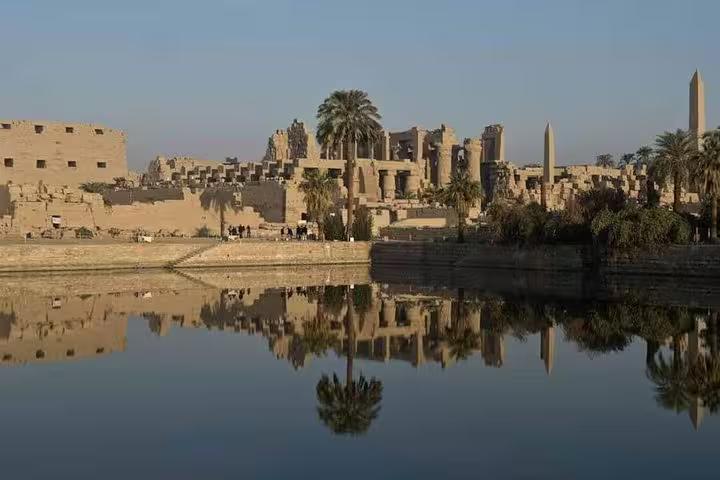 Karnak Temple ruins reflected in the Nile at sunset, part of a private Luxor day trip from Hurghada