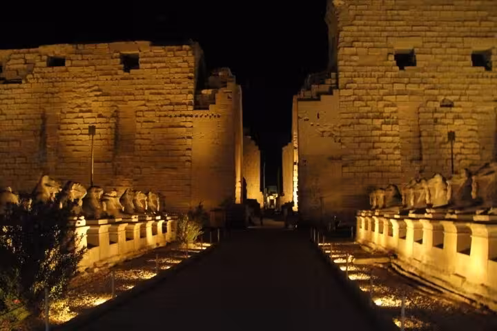 Night walkway lined with ram-headed sphinxes at Karnak Temple Light & Sound Show in Luxor with private transfer