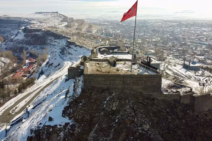 Snowy Kars Castle viewpoint with Turkish flag, highlight stop on all-inclusive private 2-day Kars Ani tour