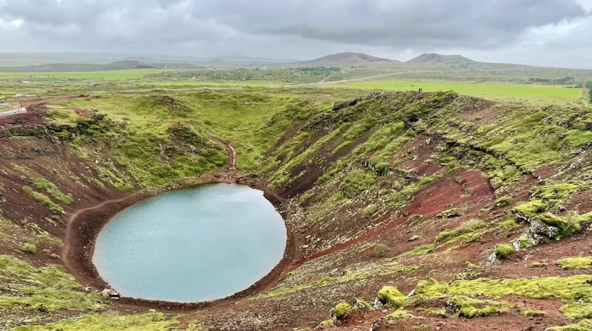 Kerid volcanic crater lake with turquoise water and red volcanic soil on Iceland's Golden Circle route