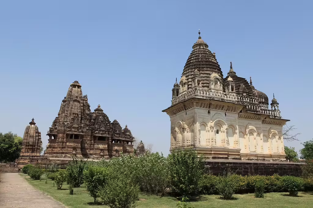 Ornate temples of Khajuraho surrounded by manicured gardens, epitomizing classical North Indian architecture.