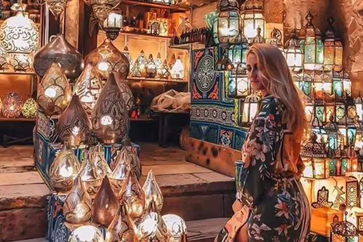 Traveler browsing Khan el-Khalili lantern shop on Alexandria Port excursion to Old Cairo and Islamic Cairo bazaar