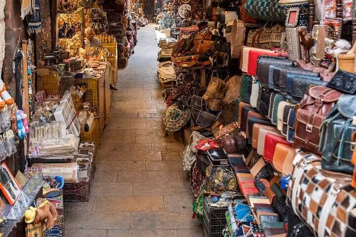 Narrow Khan El Khalili market alley with leather bags and souvenirs, part of a Cairo day tour itinerary