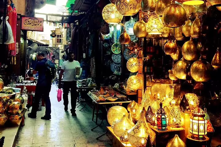 Cairo market alley lined with brass lanterns and souvenirs at Khan El Khalili on Alexandria to Cairo day trip
