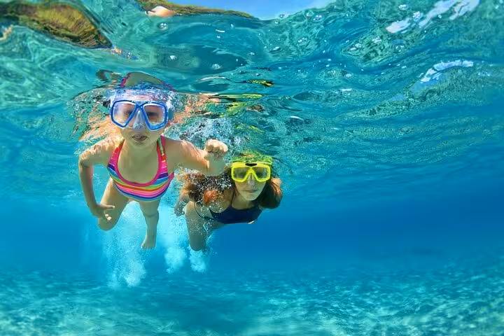Kids snorkeling in crystal-clear Red Sea at Dolphin House, Hurghada family-friendly swim with dolphins trip
