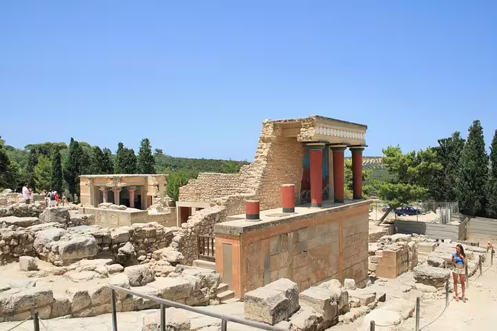 Panoramic view of Knossos Palace ruins and red columns under blue sky on a private half-day skip-the-line tour