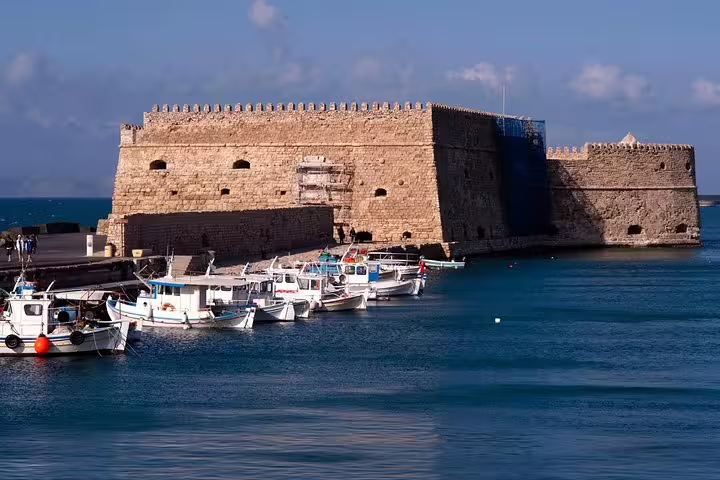 Koules Fortress in Heraklion harbor with fishing boats, scenic stop on panoramic city tour from Knossos Palace