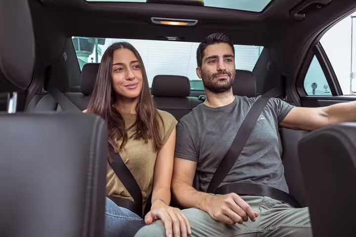 Couple riding in private car from Krakow to Auschwitz-Birkenau, comfortable round-trip transfer