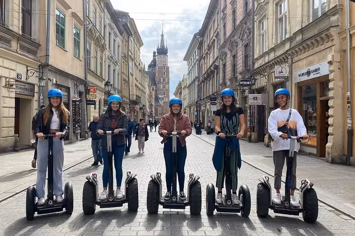 Group enjoying a Segway tour in Krakow Old Town with St. Mary's Basilica in the background.