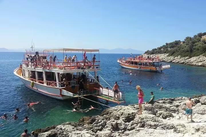 Tourists enjoy swimming near boats in clear waters during a National Park boat trip from Kusadasi or Selcuk.