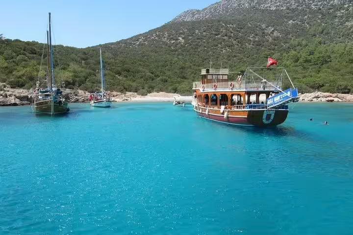 Idyllic boat anchored in turquoise waters of a secluded bay on a Kusadasi national park boat trip with lunch.