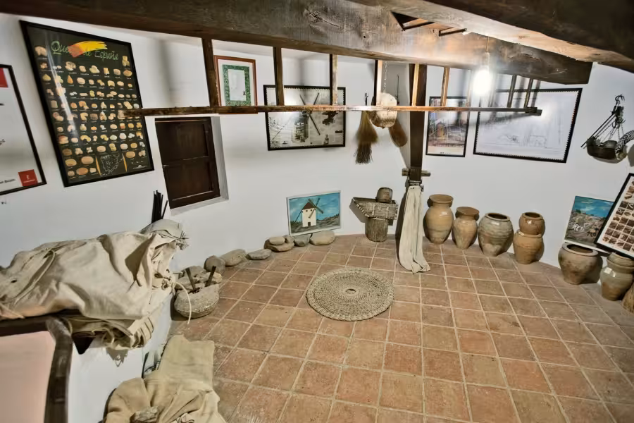 La Mancha windmill museum room with clay jars and tools, a cultural stop on the Don Quixote Tour Spain