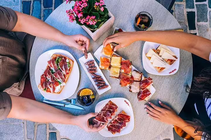 Enjoying a delicious tapas spread at La Roca Village, perfect for a gourmet shopping tour experience near Barcelona.
