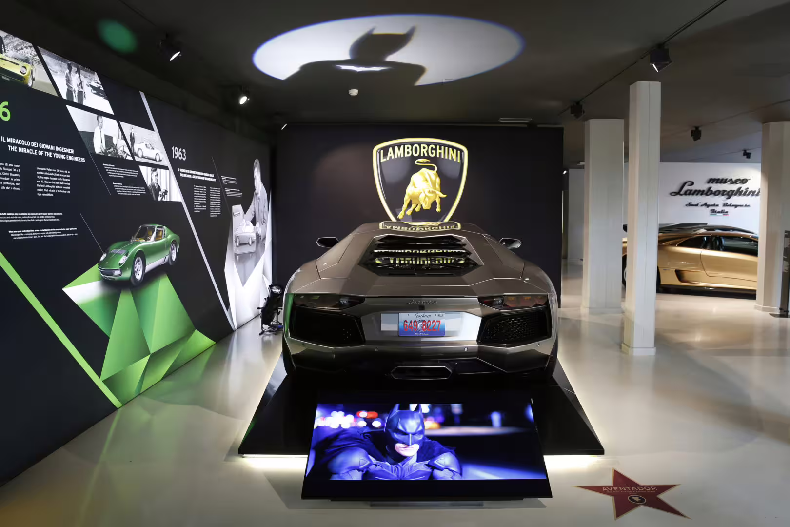 Lamborghini Museum Bologna entry: rear view of a Lamborghini supercar under the iconic bull logo display
