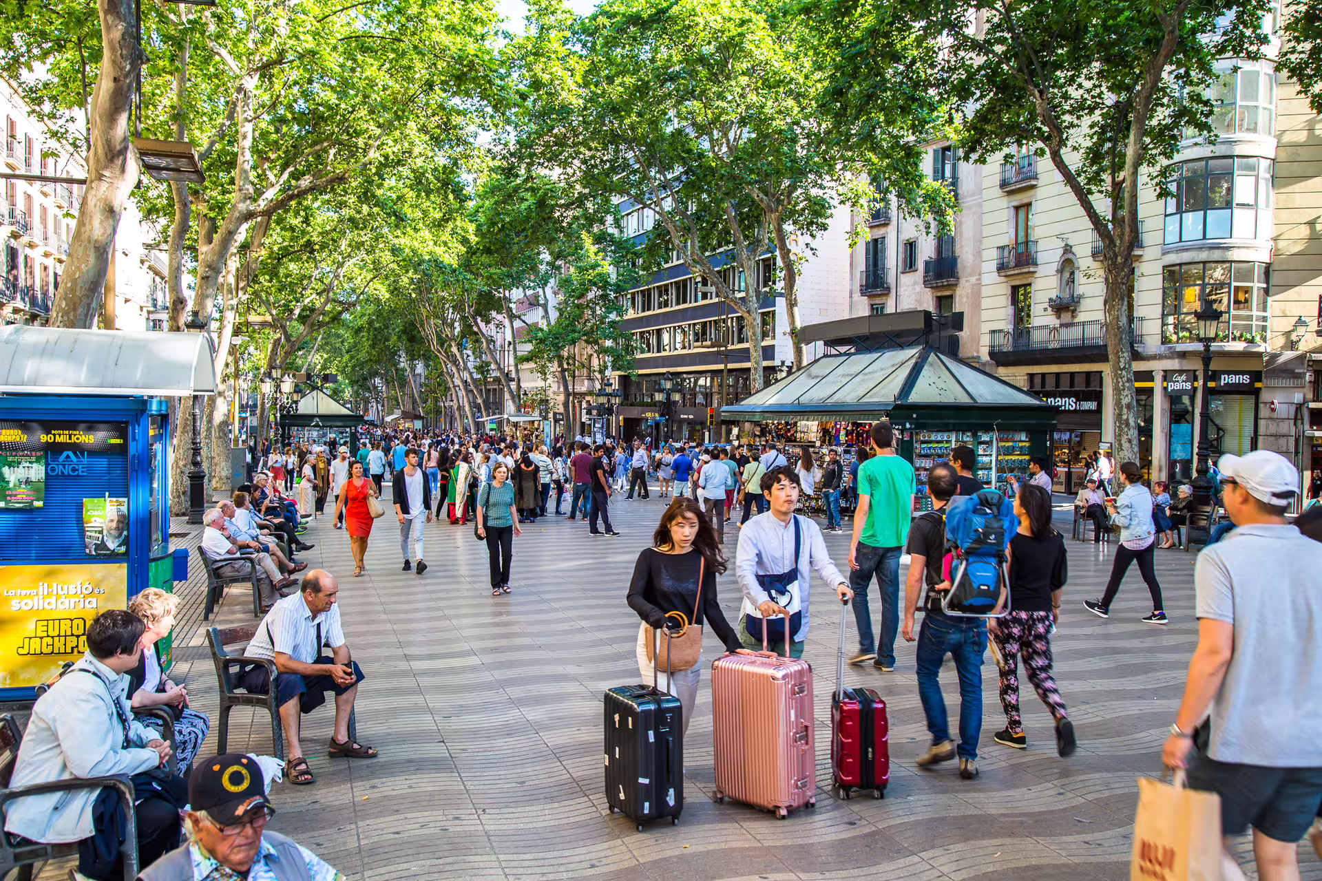 Las Ramblas Barcelona promenade near El Raval with kiosks and travelers, 1-day walking tour audioguide