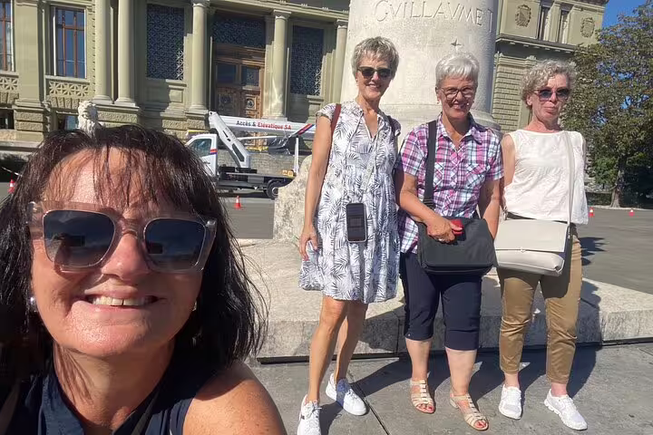 Friends posing by the William Tell monument in Lausanne, part of a city center scavenger hunt self-guided tour