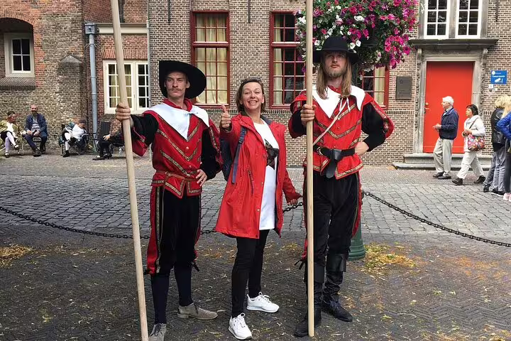 Visitors pose with Leiden city guards in historic courtyard on a half-day private guided walking tour