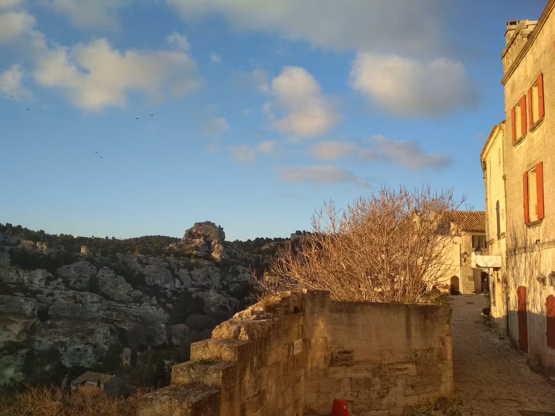 Golden-hour view from Les Baux-de-Provence ramparts over Alpilles rocks, scenic Provence lifestyle tour