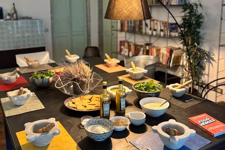 Cooking class setup featuring ingredients for Ligurian cuisine, including fresh herbs and oils in a welcoming environment.