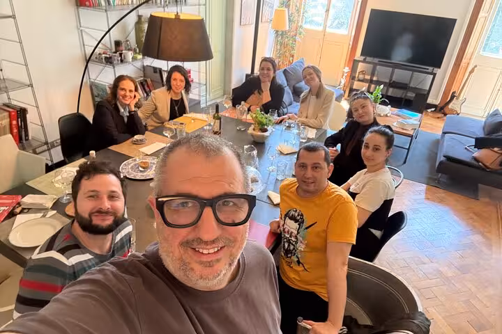 Group enjoying a Ligurian cooking class around a dining table, fostering a warm and interactive culinary experience.