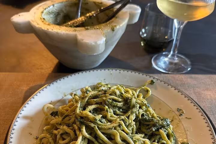 Traditional Ligurian pasta with fresh pesto sauce and wine, showcasing authentic flavors of Portofino and Cinque Terre.