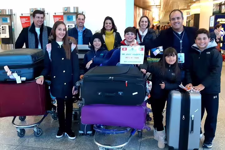 Smiling group with luggage at Lisbon Airport, ready for hotel transfer service in Lisbon.