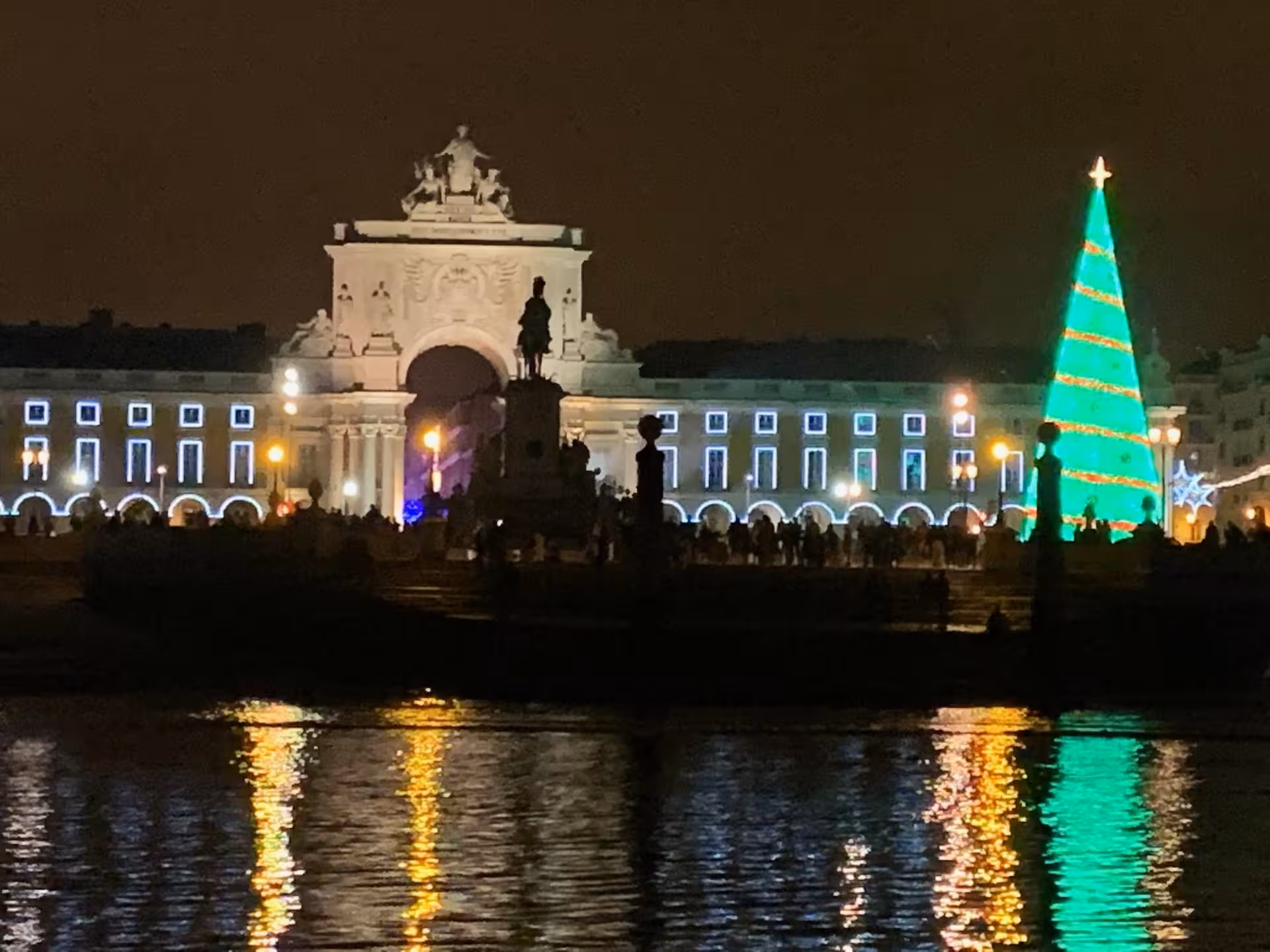 Lisbon Commerce Square at night with giant Christmas tree reflections, scenic stop on New Year’s Eve sailboat cruise