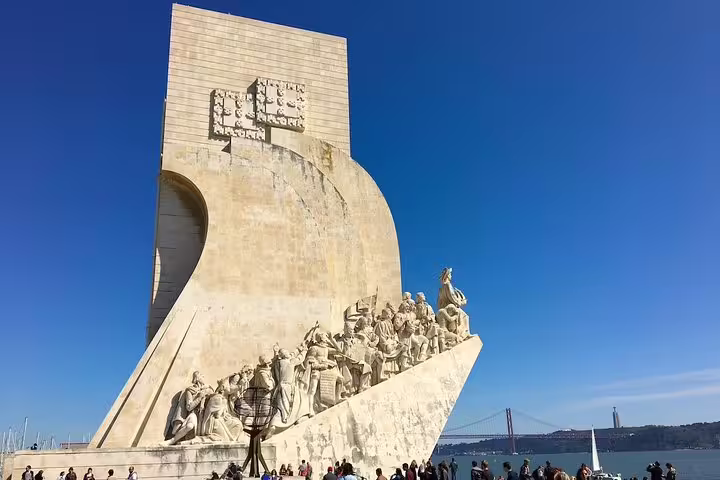 Explore Lisbon's iconic Monument to the Discoveries on a private tour, overlooking the Tagus River and 25 de Abril Bridge.